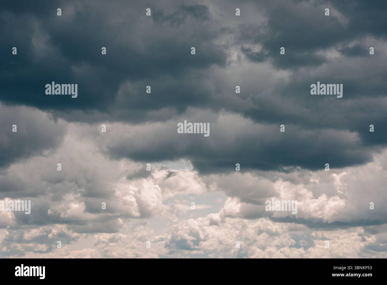 Nuvole di tempesta scure con pioggia. Nuvole di tempesta di varie forme morbide nel cielo. Condizioni meteorologiche variabili. Soffici nuvole sopra il cielo Foto Stock