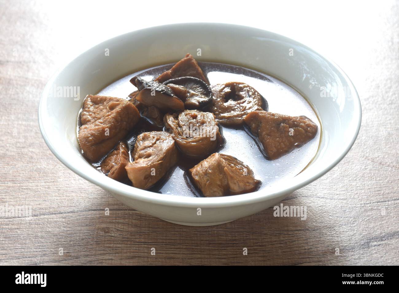 fetta bollita di tofu e glutine con zuppa di funghi neri alle erbe e cibo vegetariano nella ciotola Foto Stock