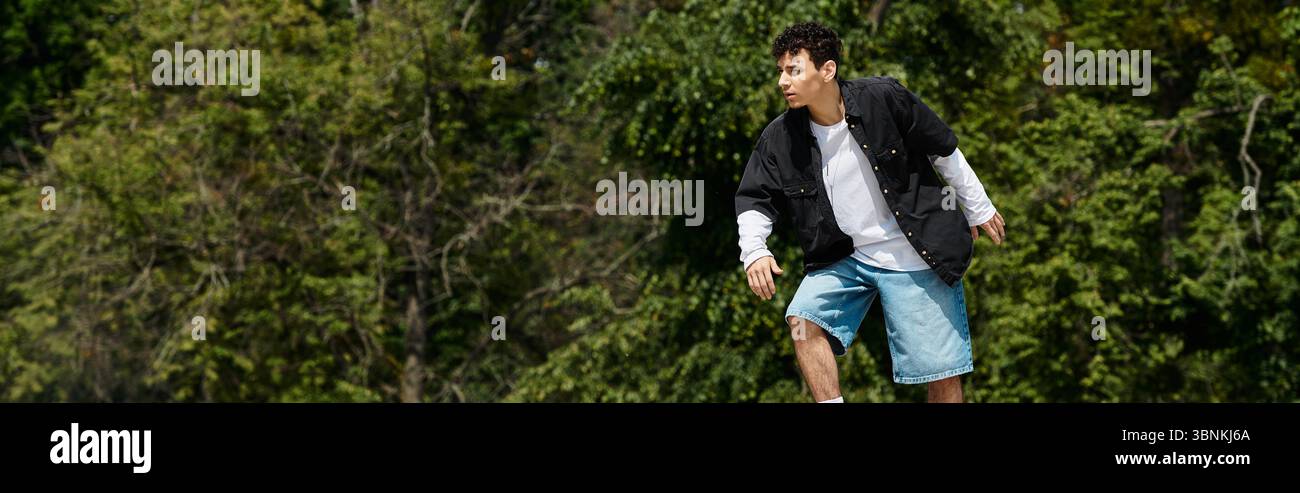 Un giovane pattina sapientemente su un prato verde fresco in un vivace parco. Foto Stock