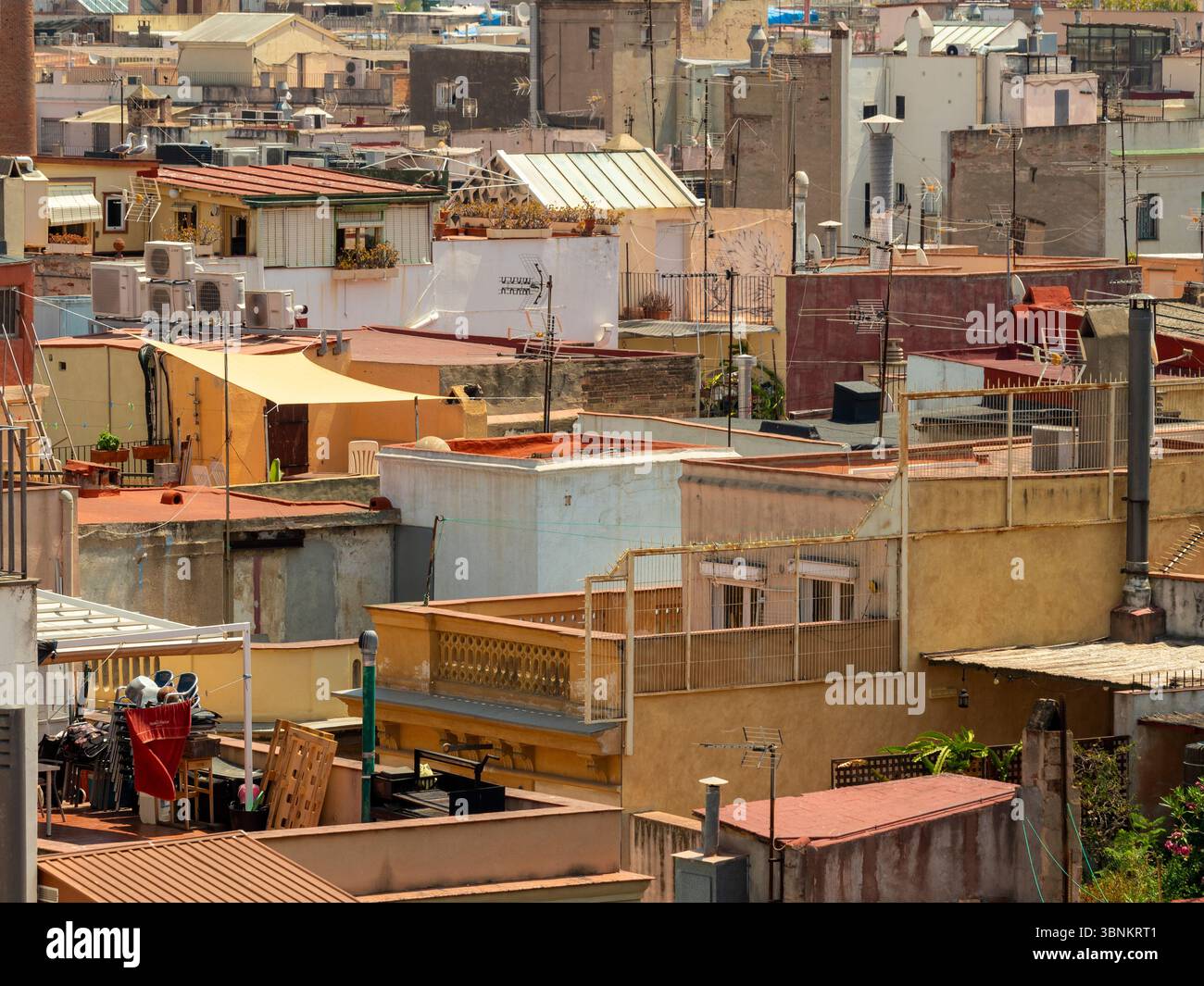 Tetti residenziali in un quartiere storico di Barcellona. Terrazze, serbatoi d'acqua e antenne creano una vista urbana strutturata. Spagna Foto Stock