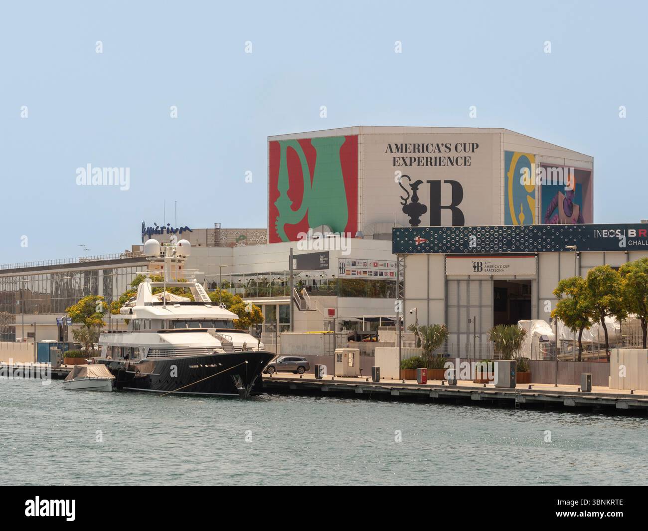 L'America's Cup Experience Building a Port Vell a Barcellona, città ospitante della 37a regata velica. Un superyacht è ormeggiato al molo. Spagna. Foto Stock
