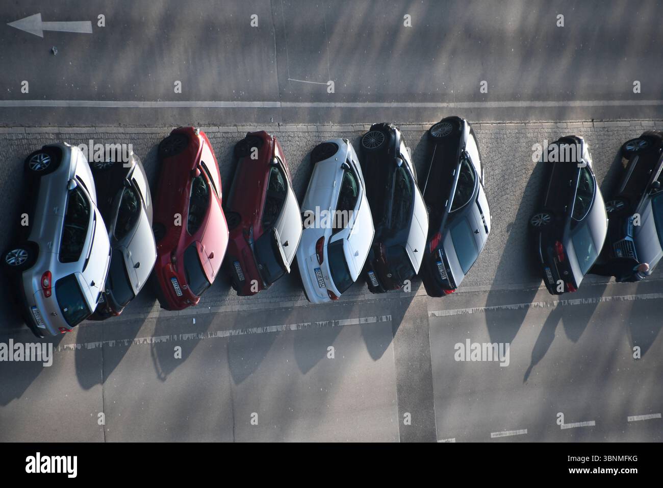 molte auto parcheggiate in fila nella riserva centrale di una strada a più corsie Foto Stock