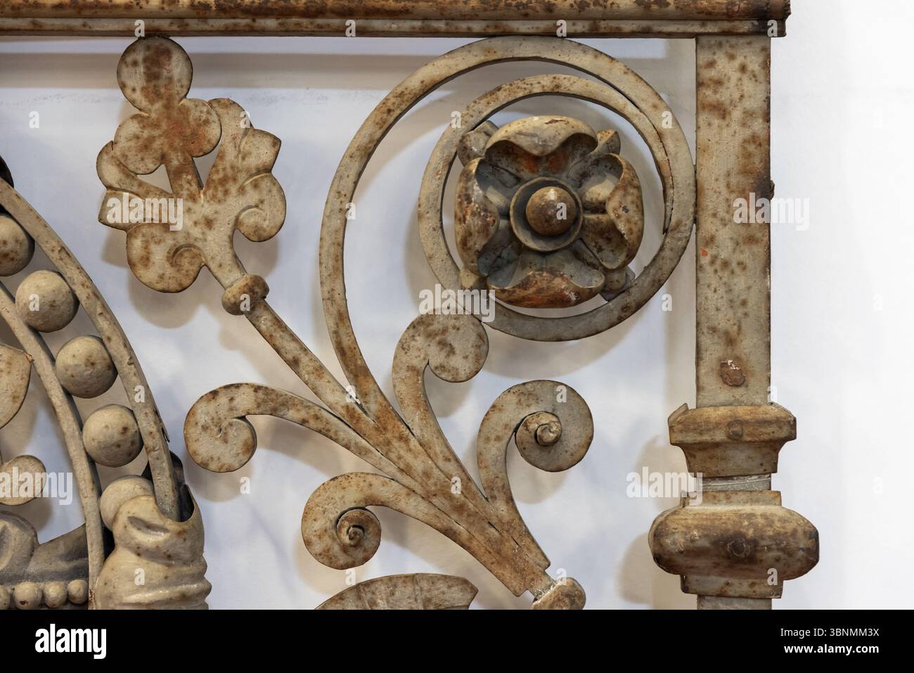 Immagine dettagliata di un pezzo ornamentale in ferro battuto con intricate pergamene e decorazioni floreali, che mostrano un'estetica rustica e vintage Foto Stock