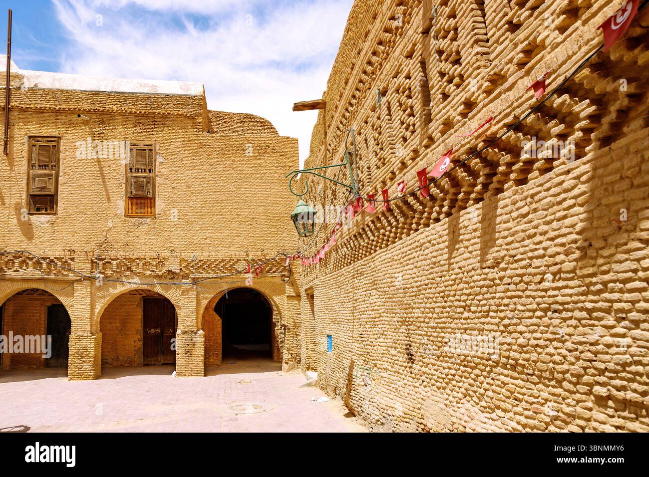 Tipica architettura in mattoni di fango con finestre nella città vecchia (Ouled el-Hadef, Medina) dell'oasi di Tozeur, Tunisia Foto Stock