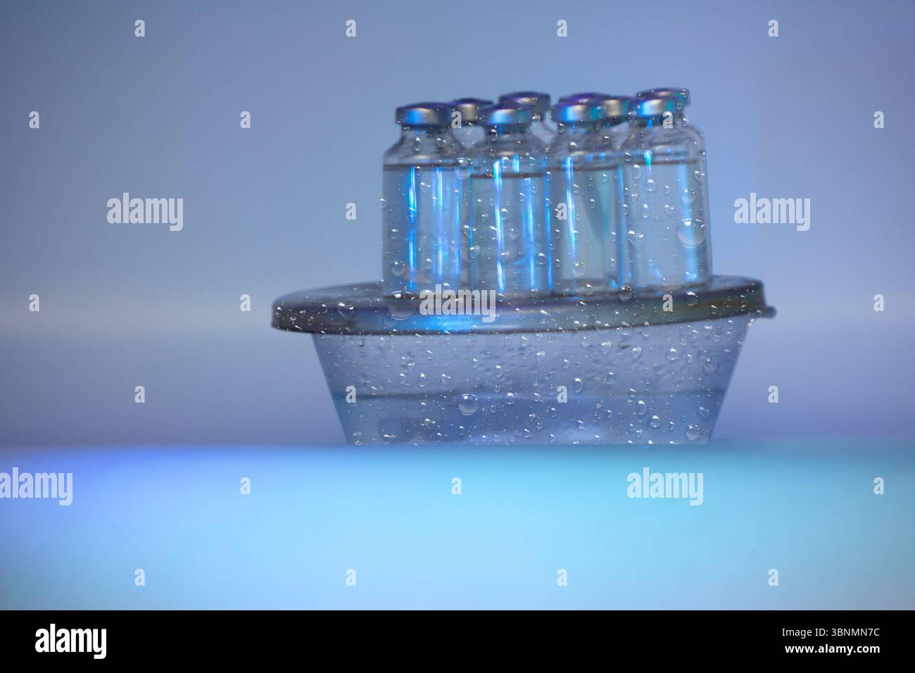 Fiale sterili con liquido vaccino sotto luce ultravioletta di tipo C concetto scientifico su vapore di ghiaccio secco per controllare Covid 19 Foto Stock