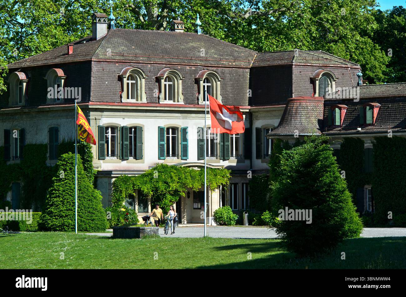 Chäteau de Penthes con la bandiera nazionale svizzera e la bandiera del Cantone di Ginevra nel Parco di Penthes, Pregny-Chambesy, Ginevra, Svizzera Foto Stock