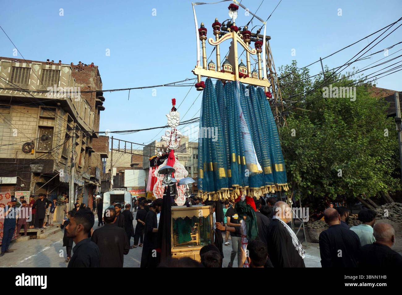 I musulmani sciiti piangono l'Imam Hussain (A.S) partecipano alla processione religiosa per mostrare la loro devozione e il loro rispetto per la culla mentre ricordano i martiri di Karbala, in relazione al VII Muharram-ul-Haram, a Gujranwala giovedì 3 luglio 2025. Foto Stock
