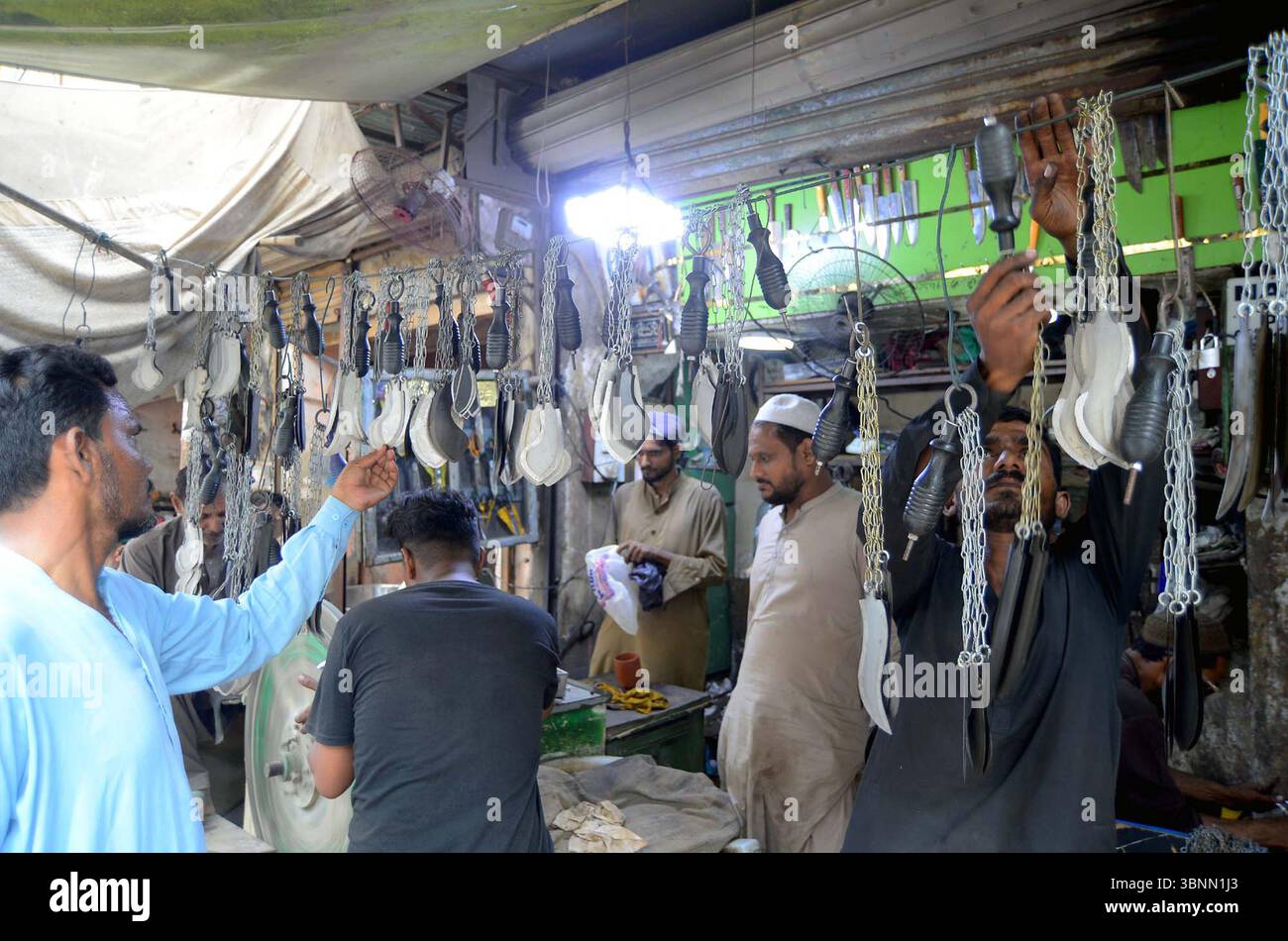 Zanjeer (coltelli con catena) sta vendendo in un negozio durante il mese Santo di Muharram-ul-Haram, situato nella zona di Bohrapir a Karachi giovedì 3 luglio 2025. Foto Stock