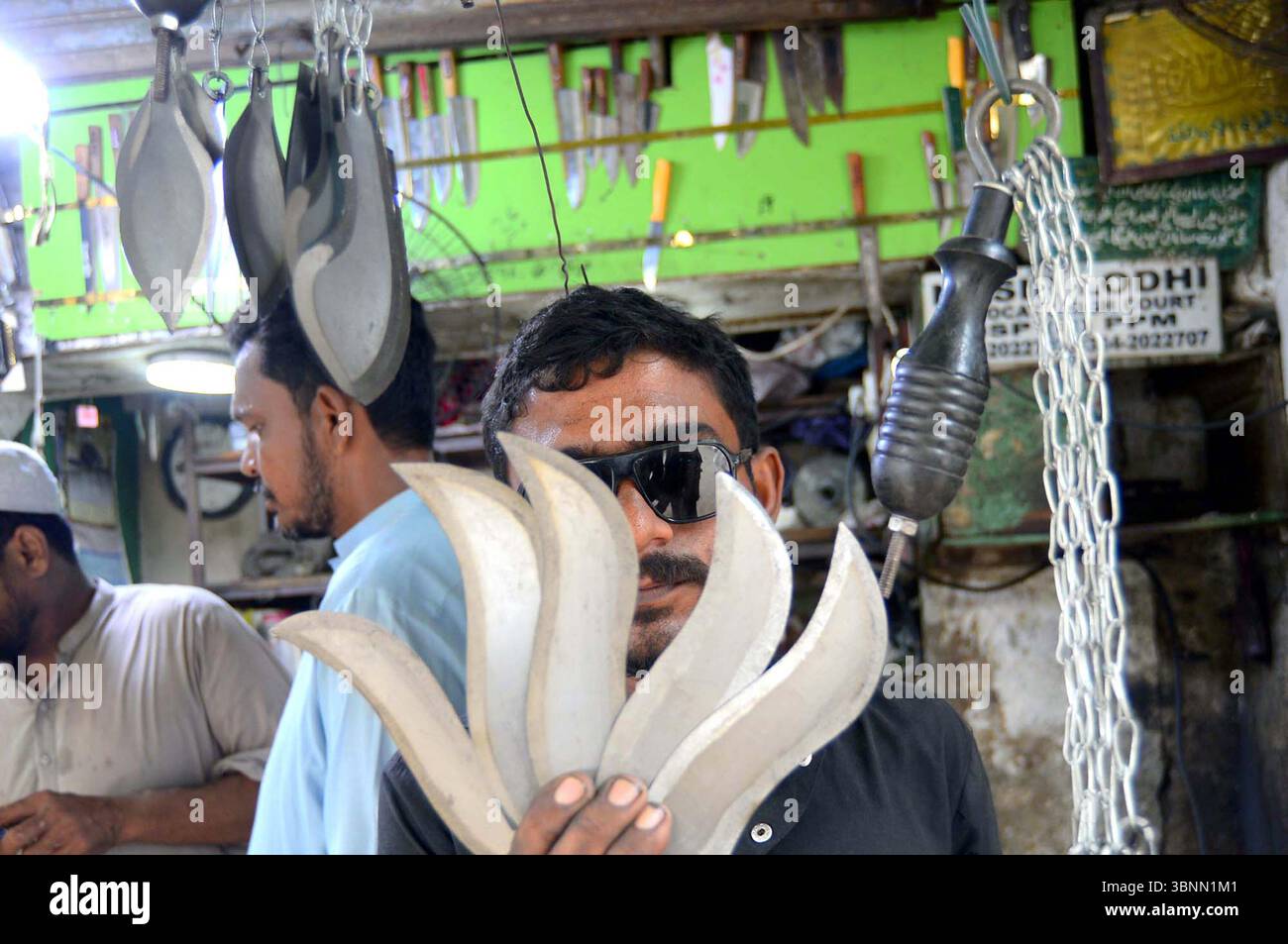 Zanjeer (coltelli con catena) sta vendendo in un negozio durante il mese Santo di Muharram-ul-Haram, situato nella zona di Bohrapir a Karachi giovedì 3 luglio 2025. Foto Stock