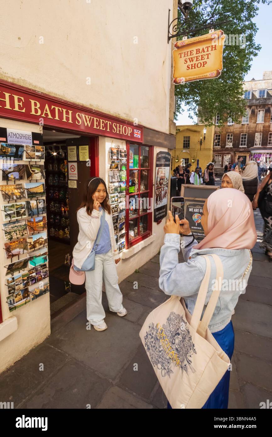 Inghilterra, Somerset, Bath, Abbey Green, turisti asiatici che scattano foto ricordo di fronte al Bath Sweet Shop Foto Stock