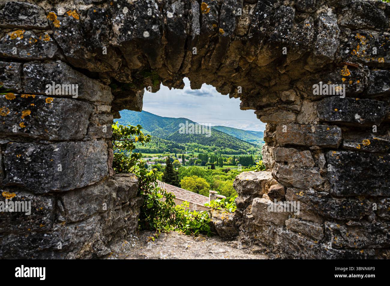 Passando attraverso l'arco di pietra, paesaggio verde sullo sfondo Foto Stock