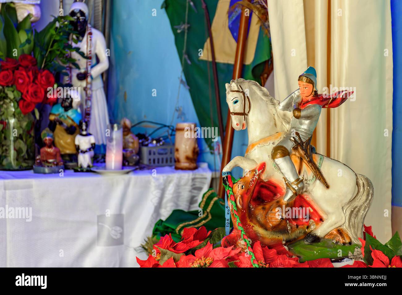 Immagine di San Giorgio sul suo cavallo con un altare Umbanda sullo sfondo Foto Stock