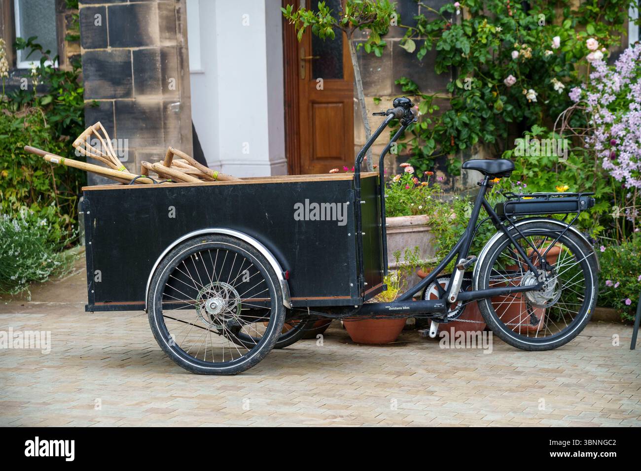 Bicicletta a tre ruote utilizzata per trasportare attrezzature da giardino Foto Stock
