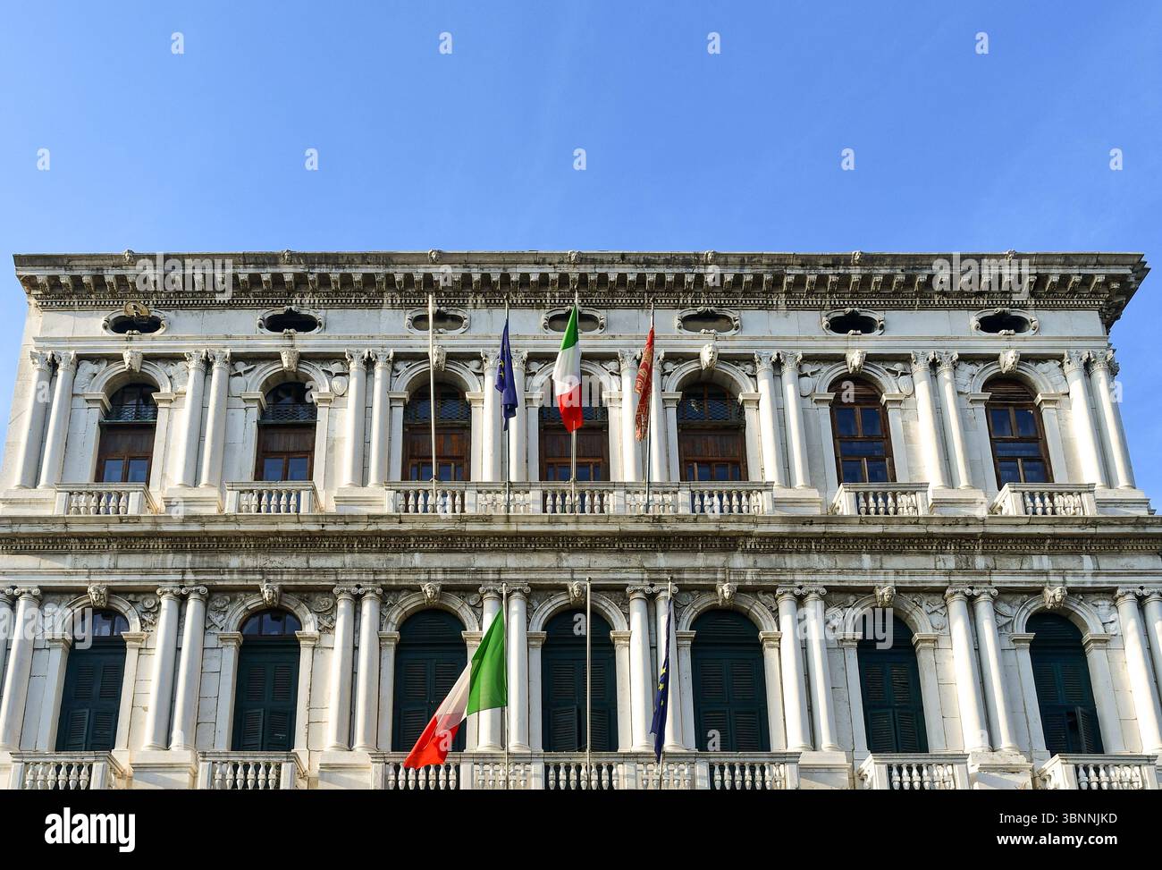 Sezione alta del Palazzo Corner della Ca' Granda, sede della Provincia di Venezia e della Prefettura, con bandiere italiane, europee e veneziane, Venezia Foto Stock
