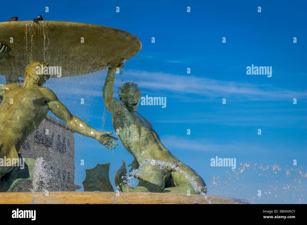 La Valletta, Malta - 9 febbraio 2024: Primo piano dell'iconica fontana dei Tritoni con tre statue di bronzo che reggono un grande bacino Foto Stock