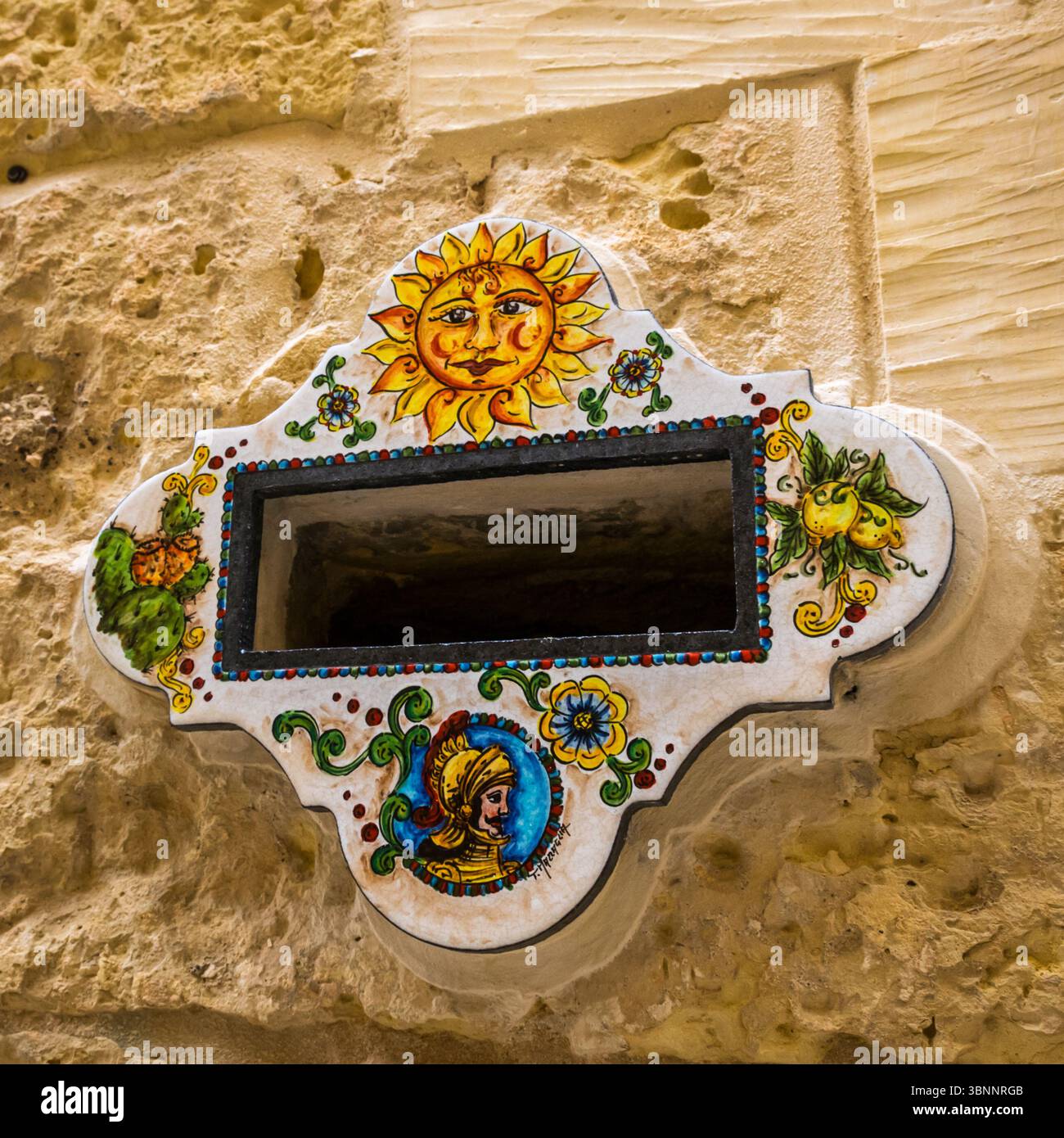 Decorazione in ceramica con cassetta postale a muro su pareti in pietra calcarea nella città di Mdina, Malta Foto Stock