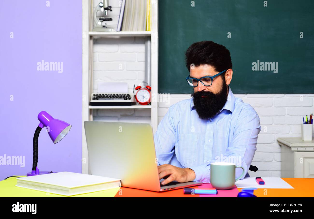 Uno studente di sesso maschile seduto alla scrivania pensa alla risposta corretta, alla soluzione di ricerca, alla preparazione per il test o l'esame, al lavoro sul progetto, preparati per l'annuncio universitario Foto Stock