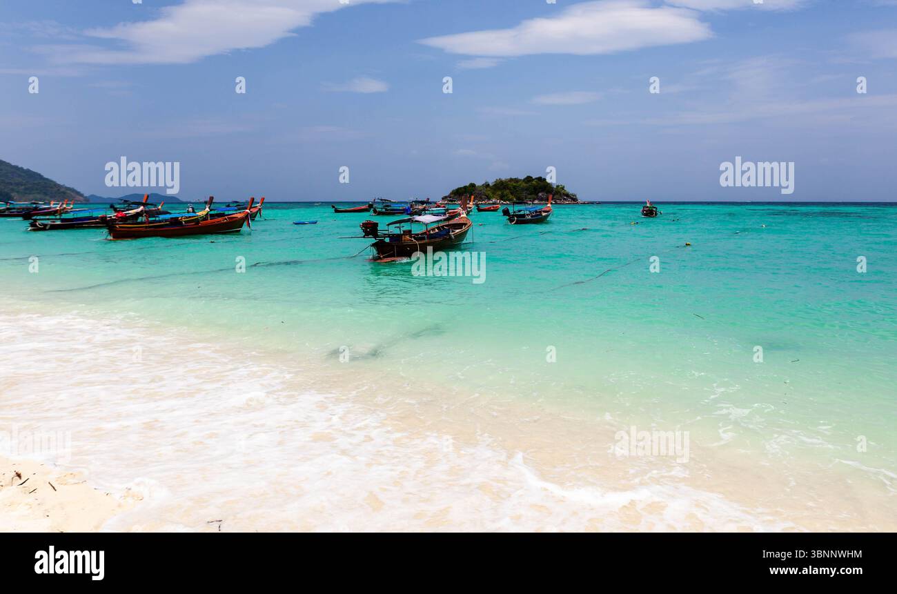 Koh Lipe, spiaggia tropicale. Mare turchese, spiaggia sabbiosa e barche a coda lunga sotto un cielo luminoso. Destinazione delle vacanze. Foto Stock