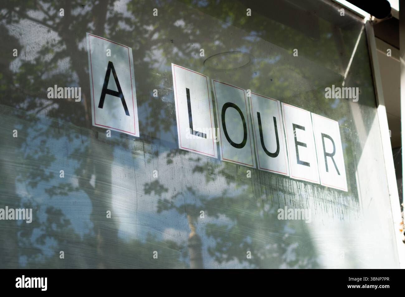 Cartello francese "in affitto" su un vetrino con riflessi che suggeriscono la disponibilità commerciale o residenziale. Foto Stock