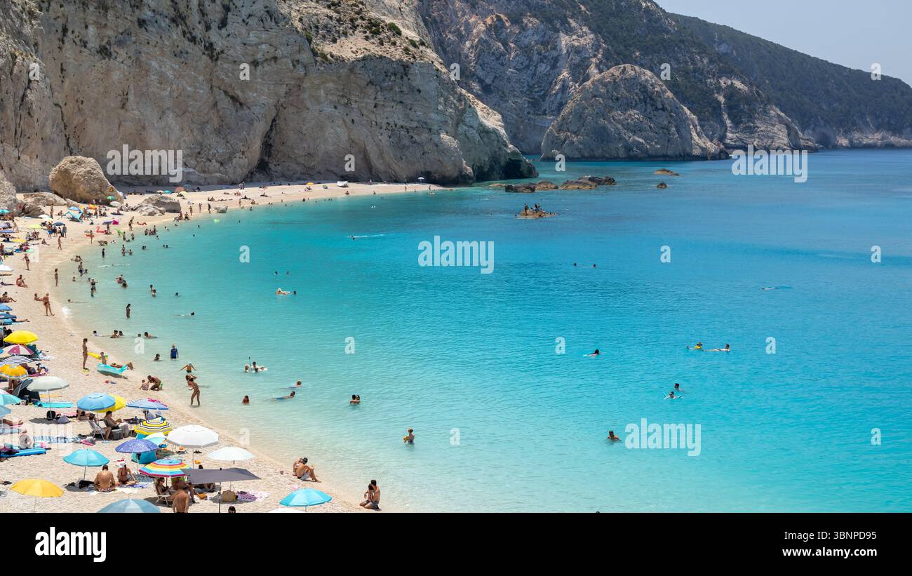 spiaggia affollata, acque turchesi e scogliere rocciose Foto Stock