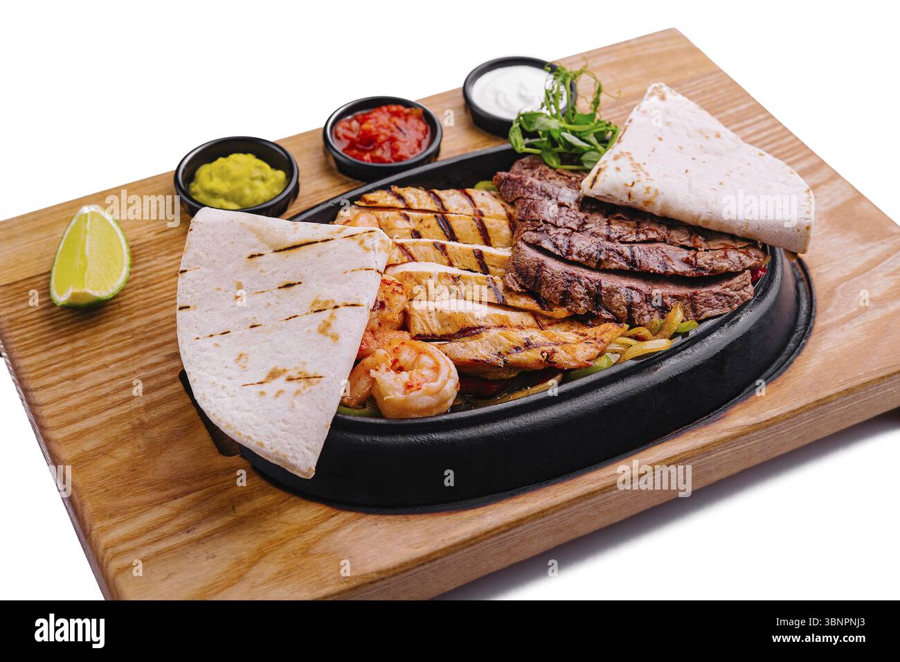 Fajitas di manzo e gamberi su un piatto di ghisa sfrigolante Foto Stock