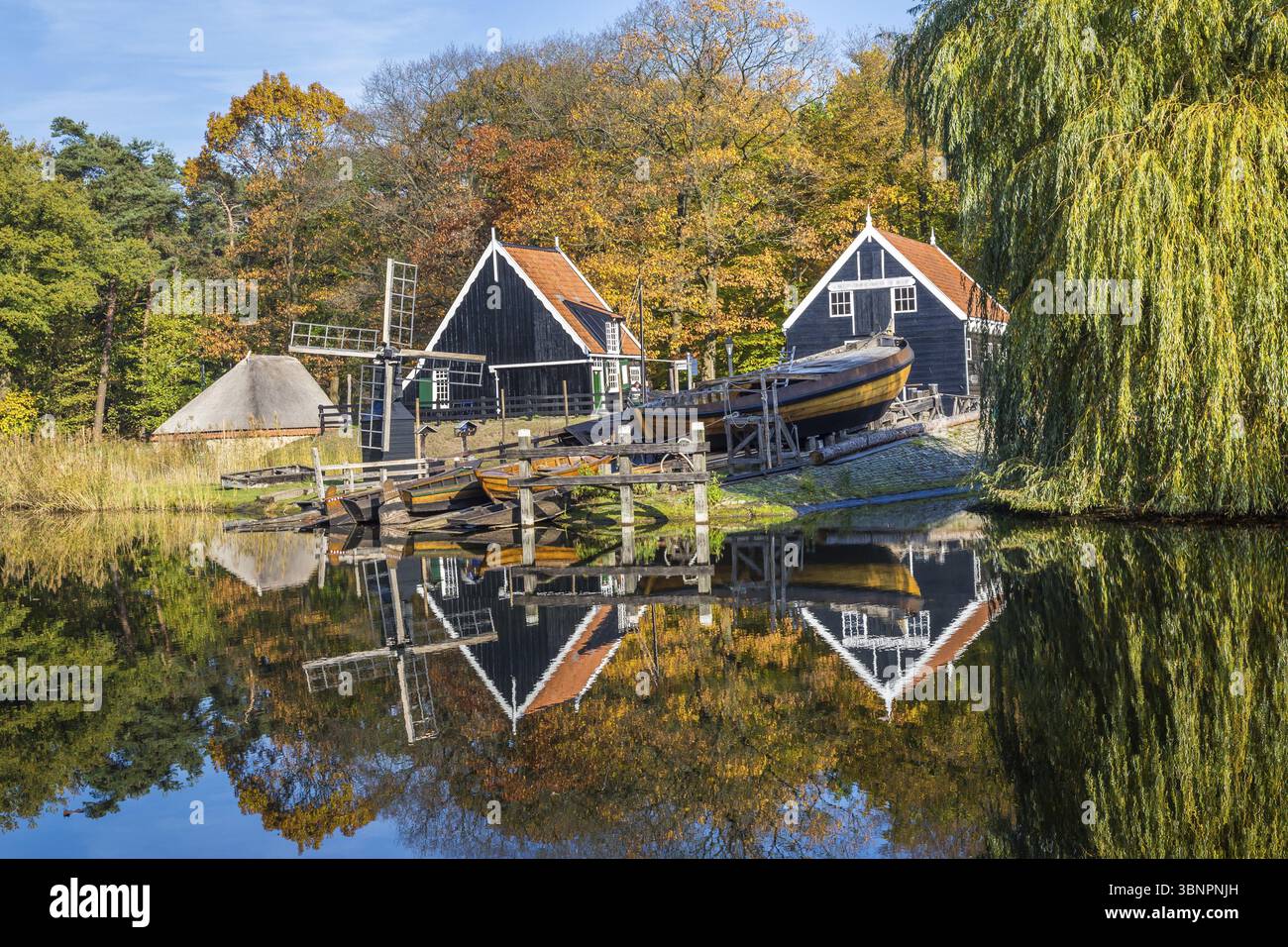 Storica scena olandese con un vecchio cantiere navale, granaio in legno e il mulino a vento di acqua nel museo a cielo aperto in Arnhem nei Paesi Bassi Foto Stock