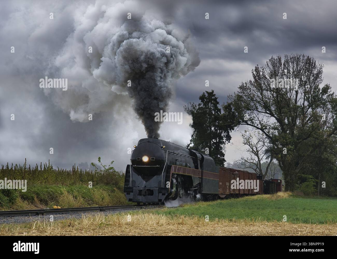 Un treno di trasporto a vapore restaurato di antiquariato che si avvicina a Head on Blowing Smoke and Steam Foto Stock