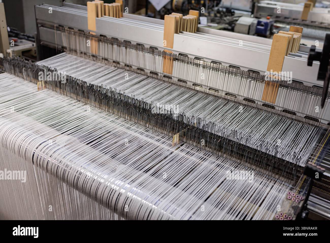 Vista dettagliata del moderno tessuto di lana intrecciata con fili allineati nell'industria tessile Foto Stock