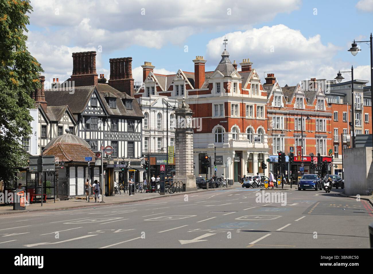 Clapham, Londra, Regno Unito. Incrocio tra Long Road e Clapham Common South. Mostra la torre dell'orologio e l'ingresso principale della stazione della metropolitana di Clapham Common. Foto Stock Clapham, Londra, Regno Unito. Incrocio tra Long Road e Clapham Common South. Mostra la torre dell'orologio e l'ingresso principale della stazione della metropolitana di Clapham Common. Foto Stock