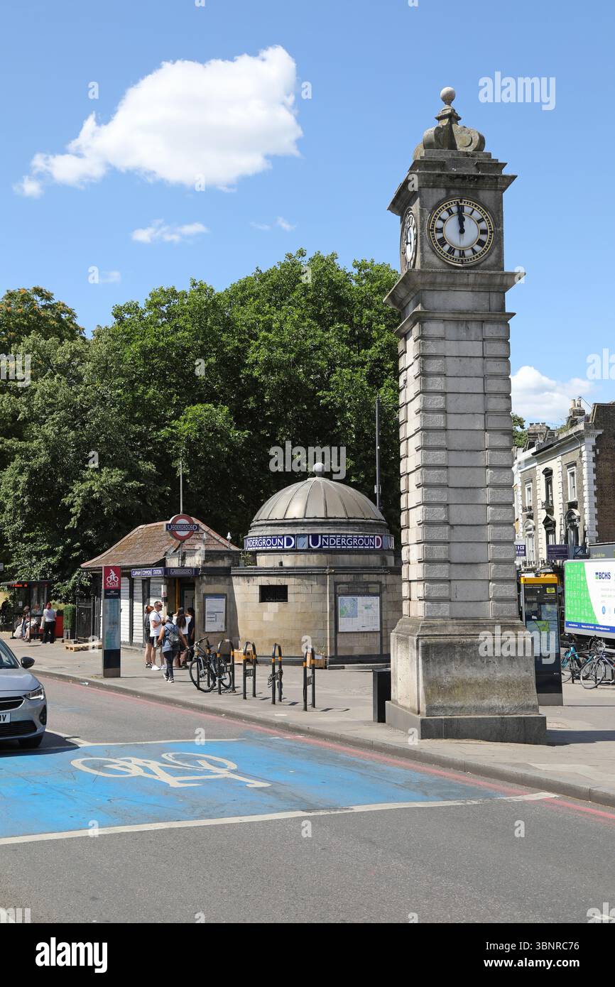 Clapham, Londra, Regno Unito. Incrocio tra Long Road e Clapham Common South. Mostra la torre dell'orologio e l'ingresso principale della stazione della metropolitana di Clapham Common. Foto Stock Clapham, Londra, Regno Unito. Incrocio tra Long Road e Clapham Common South. Mostra la torre dell'orologio e l'ingresso principale della stazione della metropolitana di Clapham Common. Foto Stock