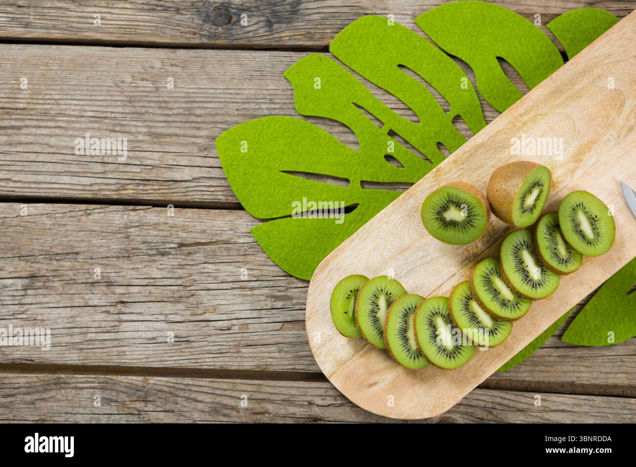 Fette di Kiwi sul tagliere di legno Foto Stock