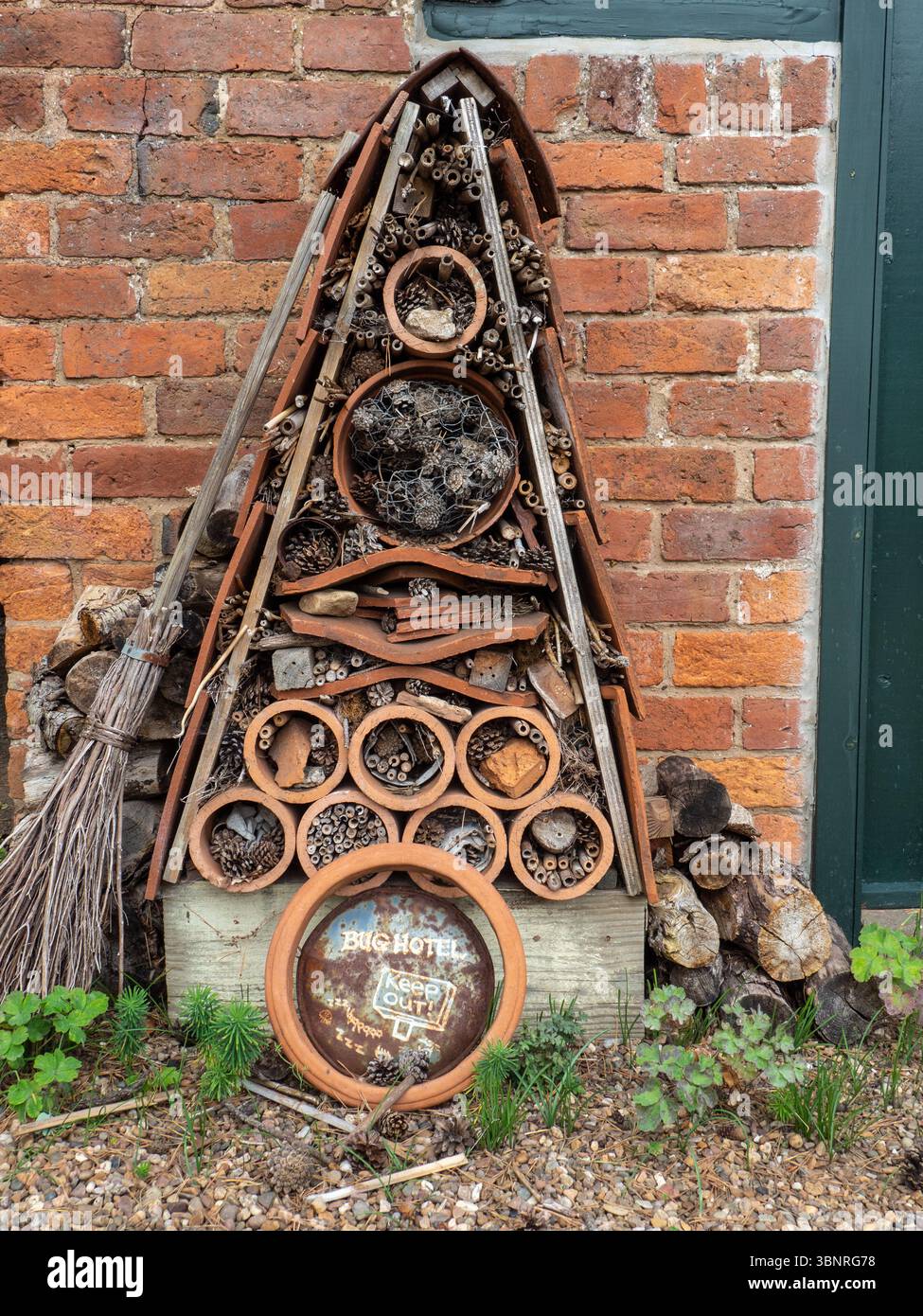 Garden bug hotel composto da ardesia, pentole di terracotta, canne, tronchi e altri oggetti riciclati, Lower Broadheath, Worcestershire, Regno Unito Foto Stock