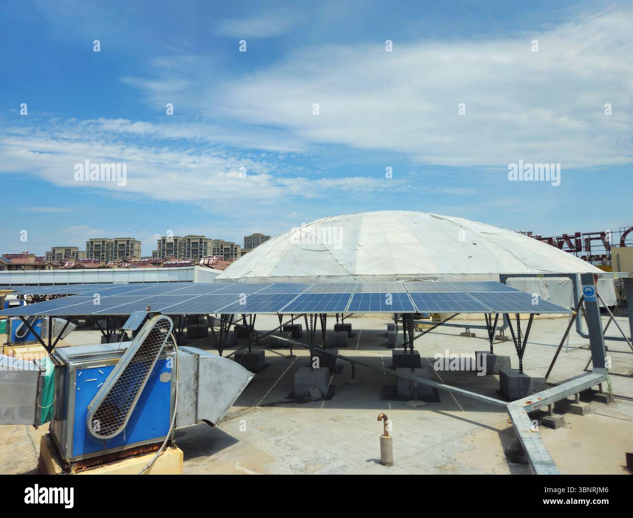 Array fotovoltaico sul tetto del centro commerciale cinese con sfondo a cupola geodetica Foto Stock