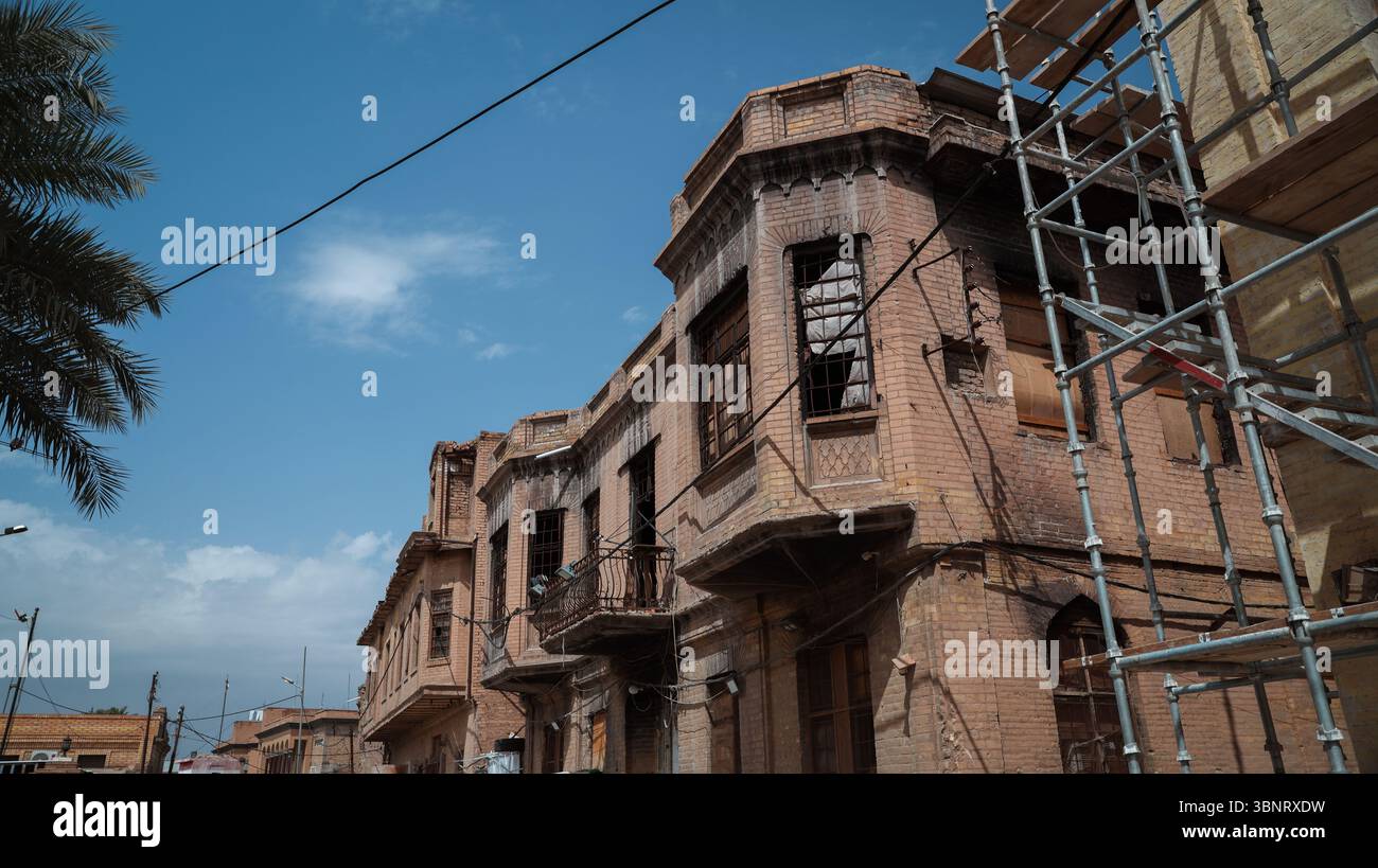 Gli edifici di Baghdad mostrano segni di sforzi di restauro sotto un cielo azzurro, rivelando una ricca storia culturale della città. Foto Stock