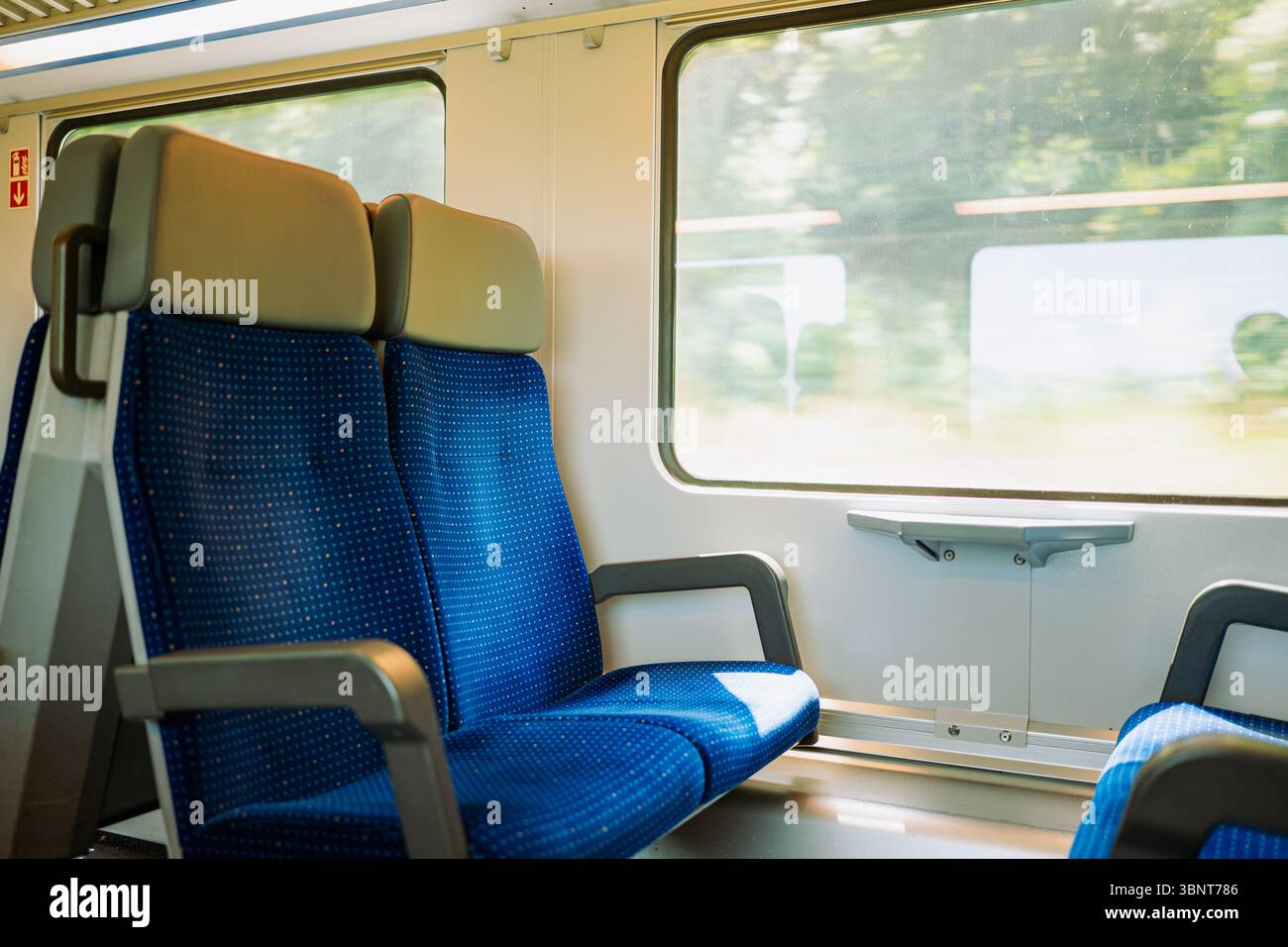 Posti vuoti sul finestrino di un treno passeggeri in Europa. Vista esterna sfocata, luminosa, grandangolare, non c'è nessuno Foto Stock
