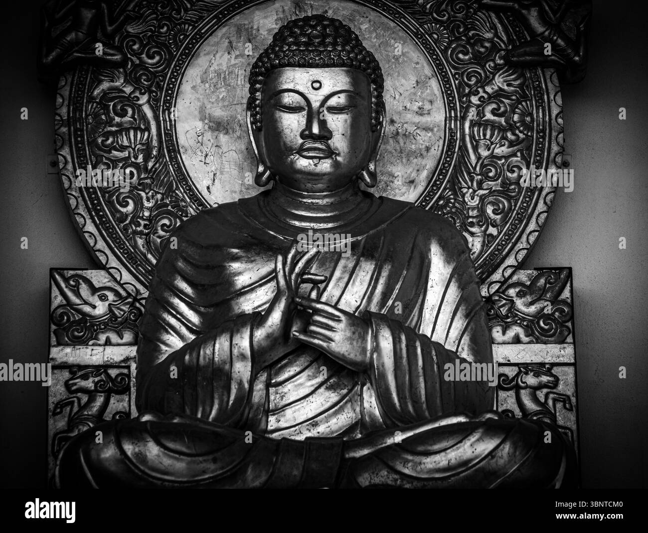 Primo piano della statua di Buddha ornata in posa di meditazione Foto Stock