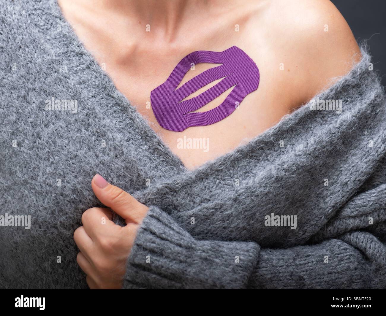 Bella giovane donna con kinesiotape sulla spalla per mobilizzare l'area dopo l'infortunio. Foto Stock