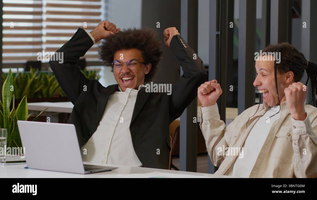 Due uomini afroamericani ragazzi uomini d'affari multirazziali multietnici colleghi d'affari colleghi colleghi colleghi colleghi colleghi che guardano un laptop nel lavoro d'ufficio Foto Stock