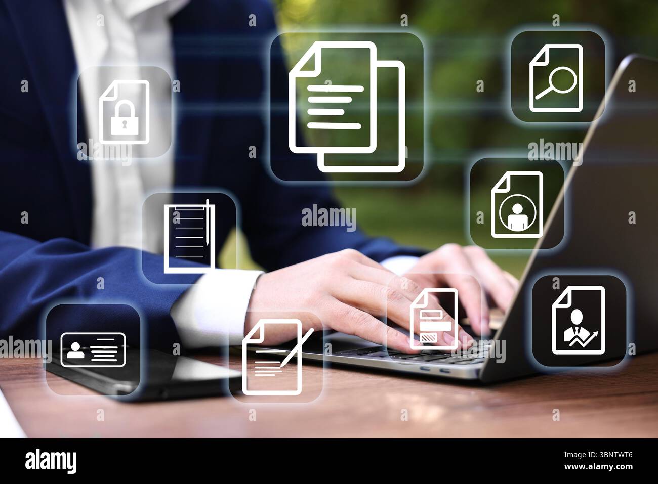 Uomo d'affari che lavora su un laptop a tavola, primo piano, diverse icone di documenti sullo schermo virtuale Foto Stock