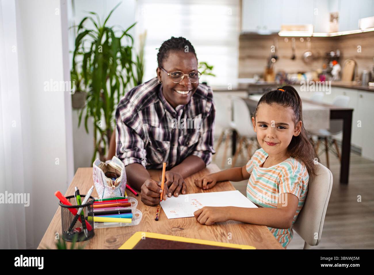 Gioiosa sessione artistica a casa con bambino e caregiver Foto Stock