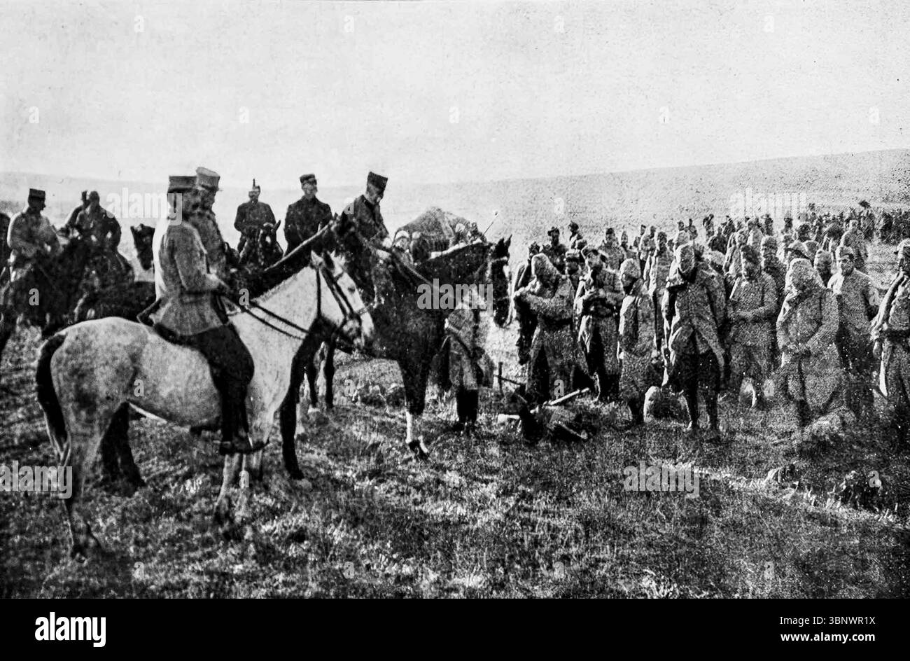 Il generale Sarrail si congratula con le truppe in prima linea durante la prima guerra mondiale. Questa immagine di l'Illustration mostra un generale a cavallo che si rivolge ai soldati riuniti sul campo, probabilmente sul fronte balcanico intorno al 1916. The Moment cattura una visita stimolante per il morale tra le difficoltà della guerra di trincea. Sarrail comandò le forze alleate nella campagna di Salonicco, un fronte meno conosciuto ma strategicamente importante. Foto Stock