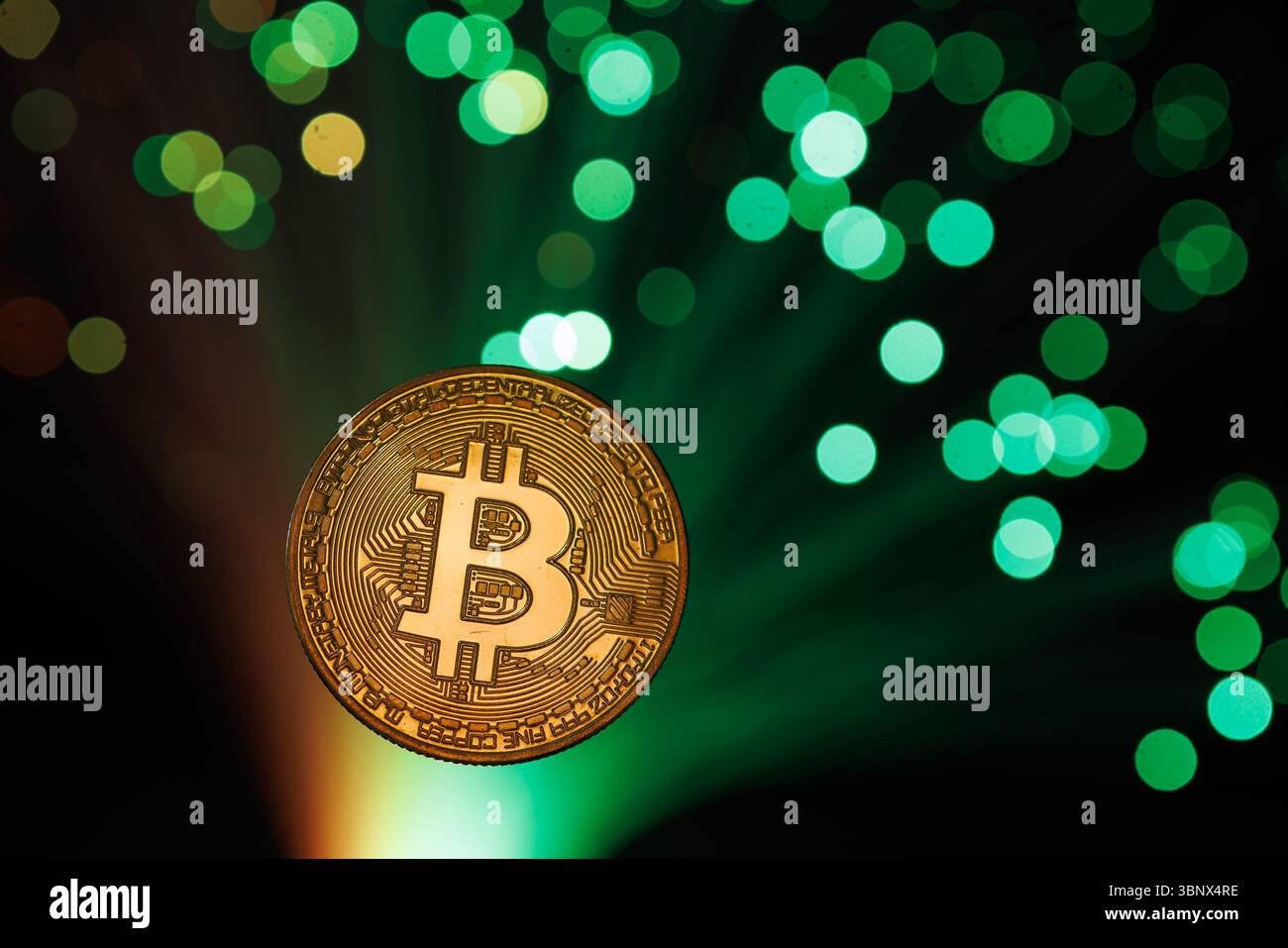 Moneta Bitcoin con luci a fibra ottica verdi, che rappresentano le tendenze di valuta digitale, finanza online e trading di criptovalute Foto Stock