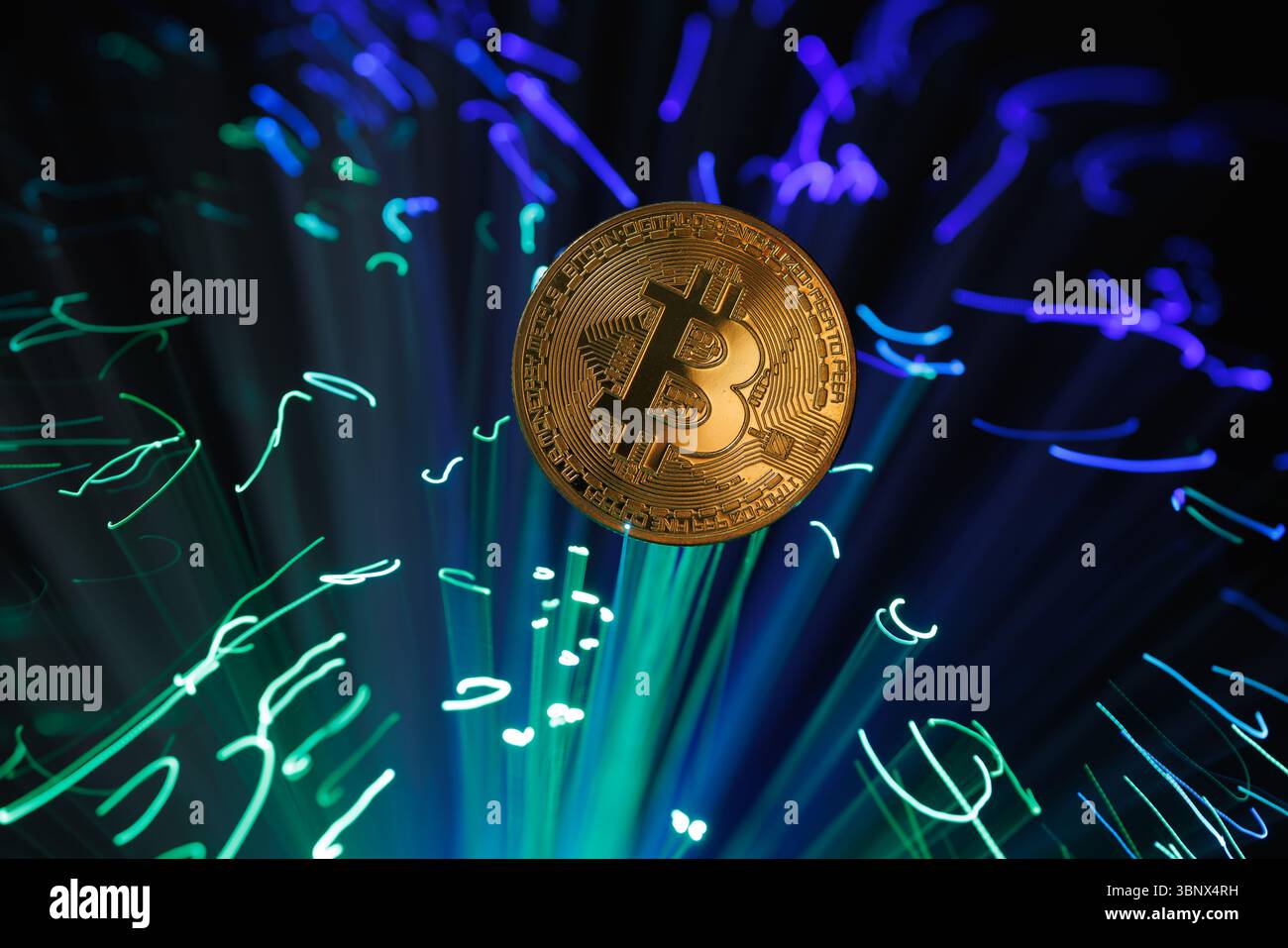 Bitcoin Coin con sfondo luminoso in fibra ottica che simboleggia le tendenze del blockchain, della valuta digitale e del trading di criptovalute Foto Stock