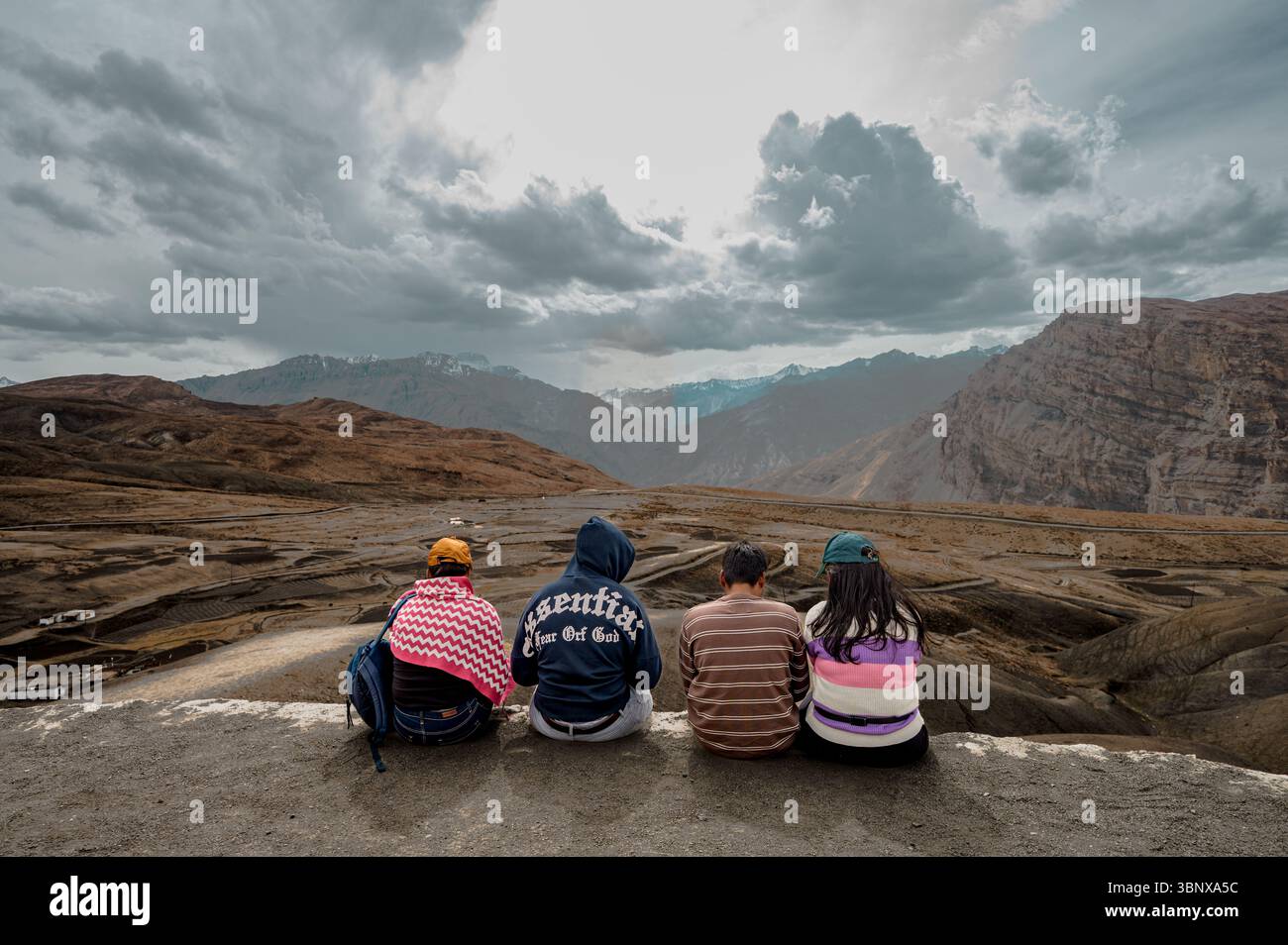 Un gruppo di amici intimi seduti al punto panoramico di Langza, immersi nelle maestose vedute dell'Himalaya, celebrando l'amicizia, la solidarietà, i ricordi di viaggio. Foto Stock