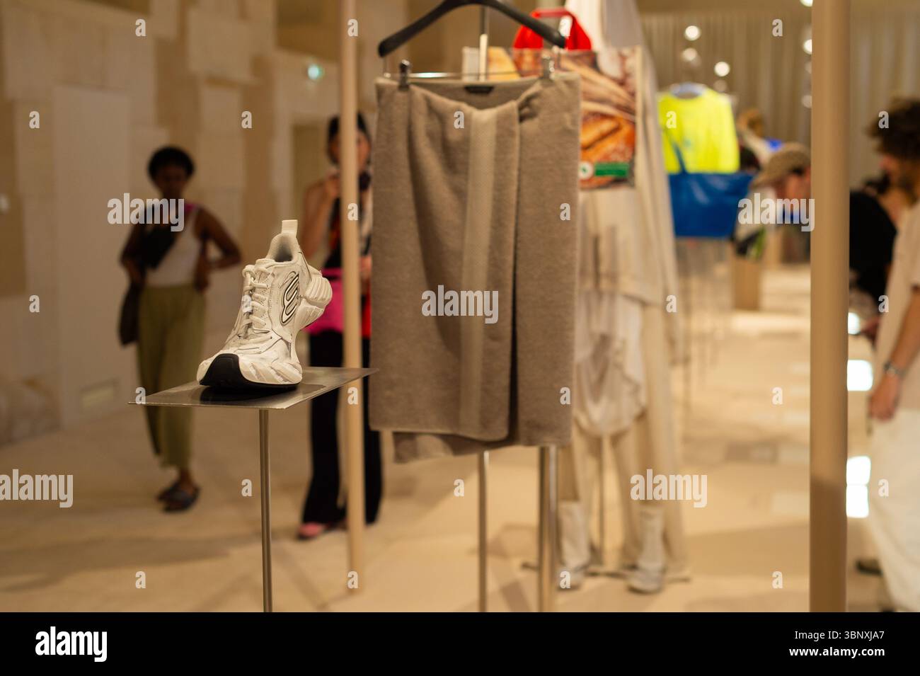 Parigi, Île-de-France / Francia - 3 luglio 2025: Una gonna grigia simile a un asciugamano e una sneaker Balenciaga bianca in mostra alla mostra. Foto Stock