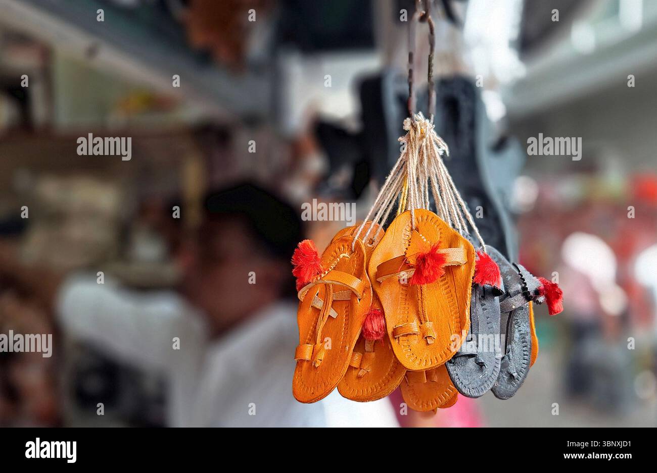 4 luglio 2025, Mumbai, Maharashtra, India: Un paio di palle Kolhapuri (sandali indiani artigianali) sono esposte in un negozio a lato della strada. Il marchio italiano di moda di lusso Prada, che ha lanciato i suoi 'sandali con anello di dito', è accusato di copiare il design ispirato alle zampe Kolhapuri (sandali indiani artigianali) senza dare il dovuto credito agli artigiani indigeni che li hanno creati nel distretto di Kolhapur nel Maharashtra secoli fa. Un contenzioso di interesse pubblico (PIL) è stato depositato presso l'alta Corte di Bombay in cerca di un risarcimento per gli artigiani di Kolhapuri chappall (sandali indiani artigianali) di Prada. (C Foto Stock 4 luglio 2025, Mumbai, Maharashtra, India: Un paio di palle Kolhapuri (sandali indiani artigianali) sono esposte in un negozio a lato della strada. Il marchio italiano di moda di lusso Prada, che ha lanciato i suoi 'sandali con anello di dito', è accusato di copiare il design ispirato alle zampe Kolhapuri (sandali indiani artigianali) senza dare il dovuto credito agli artigiani indigeni che li hanno creati nel distretto di Kolhapur nel Maharashtra secoli fa. Un contenzioso di interesse pubblico (PIL) è stato depositato presso l'alta Corte di Bombay in cerca di un risarcimento per gli artigiani di Kolhapuri chappall (sandali indiani artigianali) di Prada. (C Foto Stock