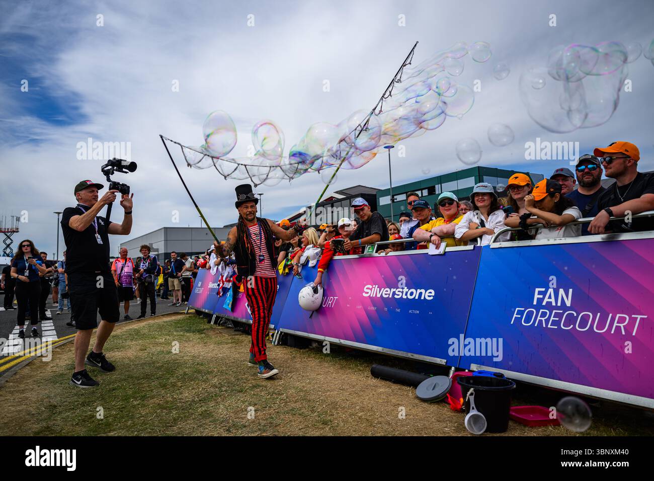 TOWCESTER, REGNO UNITO. 4 luglio: Un artista intrattiene i tifosi al fan Forecourt fuori dal paddock durante il Qatar Airways British Grand Prix 2025 al circuito di Silverstone venerdì 4 luglio 2025 a TOWCESTER, INGHILTERRA. Crediti: Taka G Wu/Alamy Live News Foto Stock