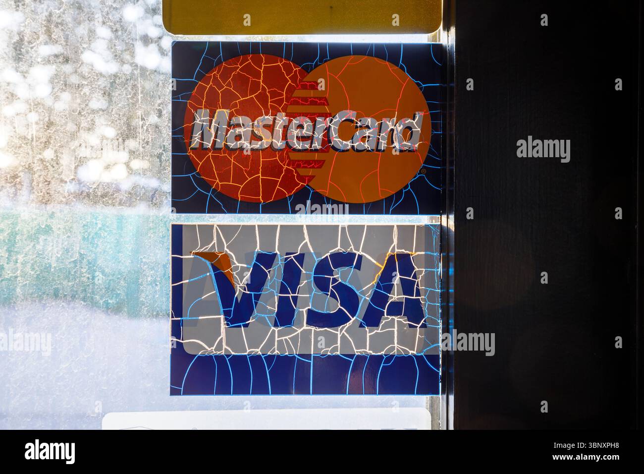 Adesivi con logo Mastercard e VISA usurati su una porta. Foto Stock