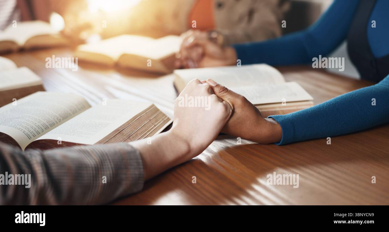 Mano, Bibbia e persone con preghiera per la religione, guida o sostegno con le Scritture per il culto. Cristianesimo, fede e gruppo per tavolo, libro Foto Stock