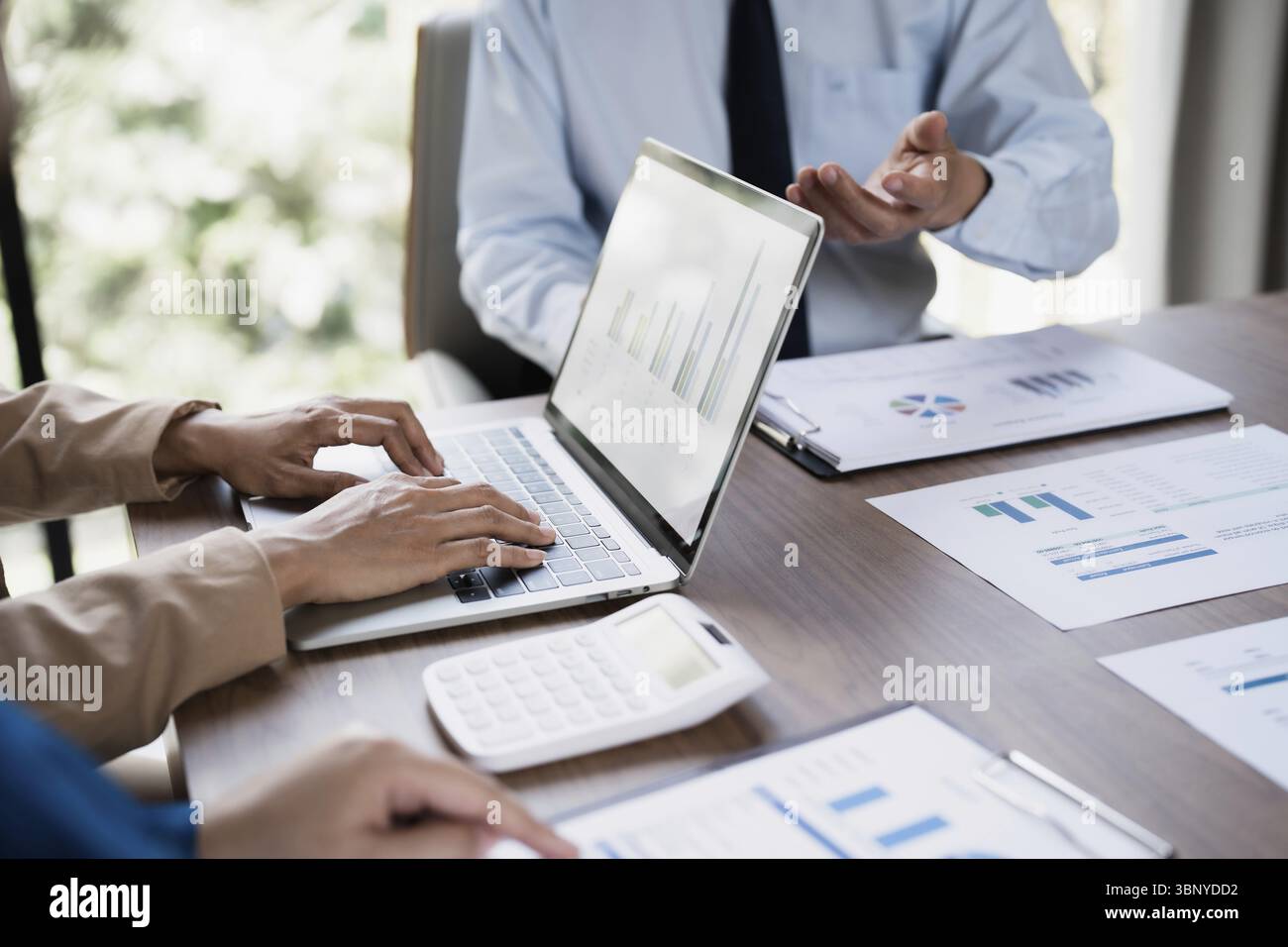 Analista aziendale che calcola i dati relativi al fatturato in ufficio Foto Stock
